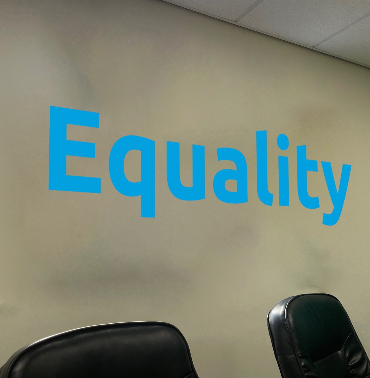 blue mural that says 'equality' on our core values wall at Aspire CRM's UK office